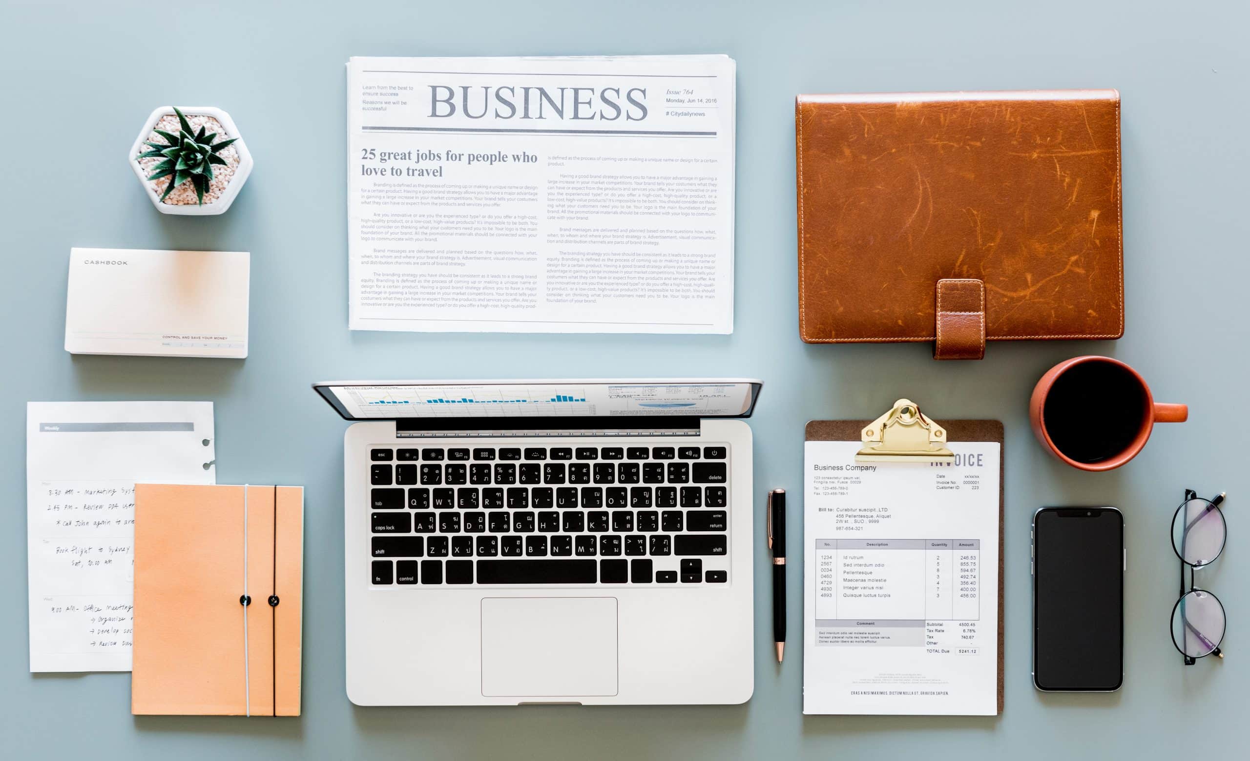 Un bureau avec un ordinateur, un journal et des papiers