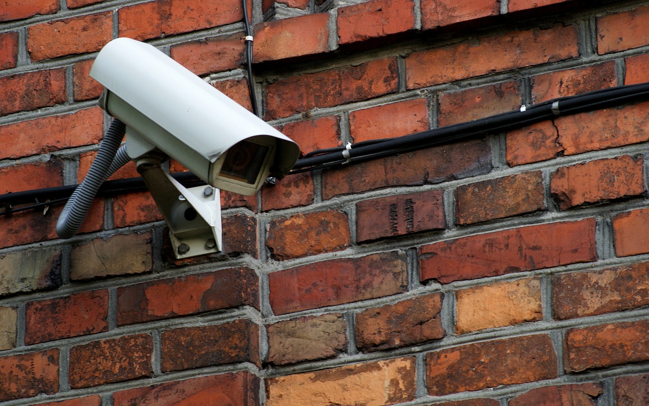 camera de vidéosurveillance sur un mur en briques rouges